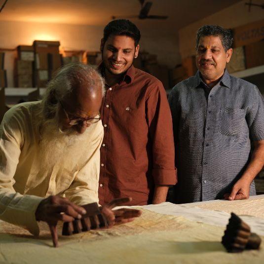 Three generations of craftsmen at their block printing workshop with the eldest demonstrating the craft | ALORAA